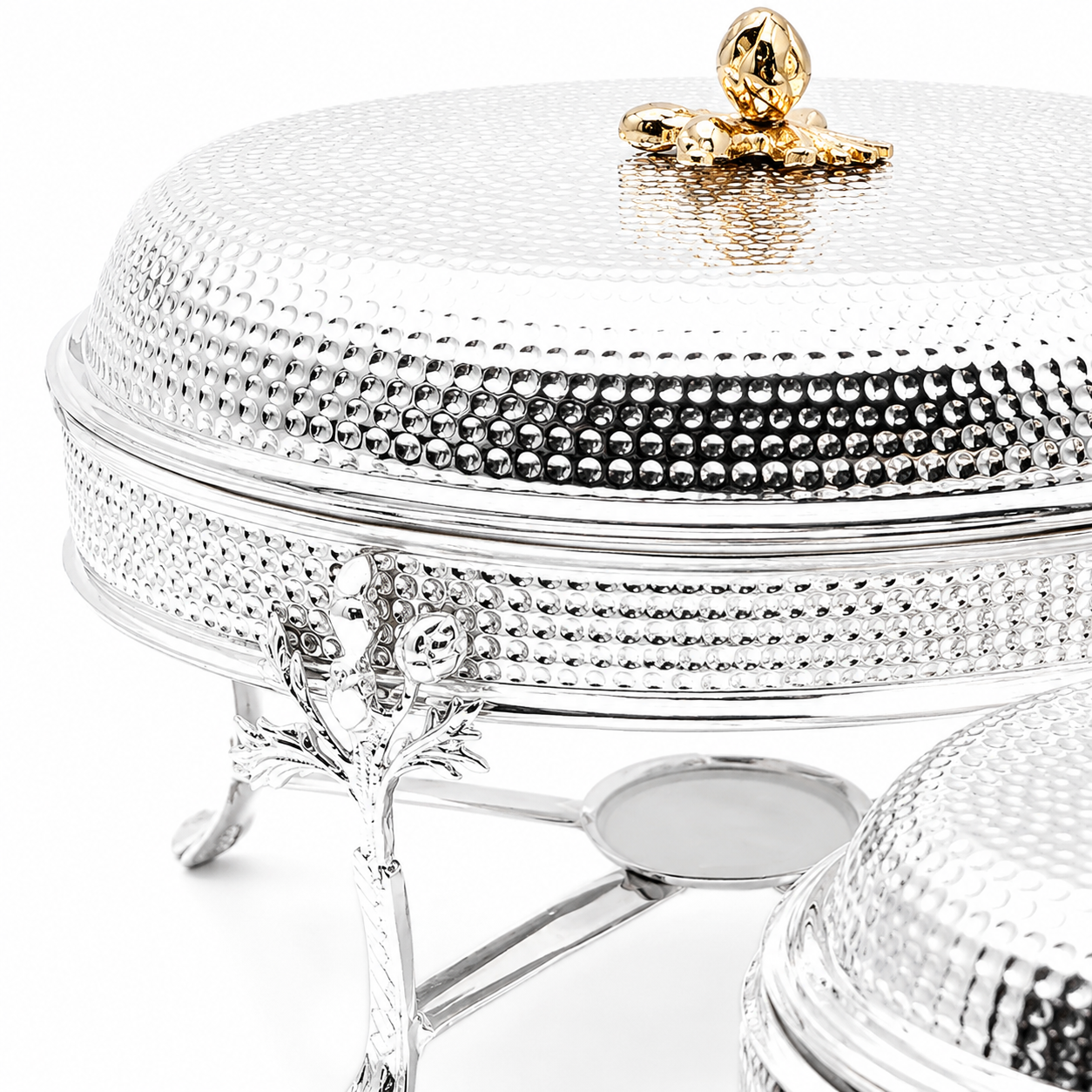 Decorative silver serving dish with a gold handle on a white background