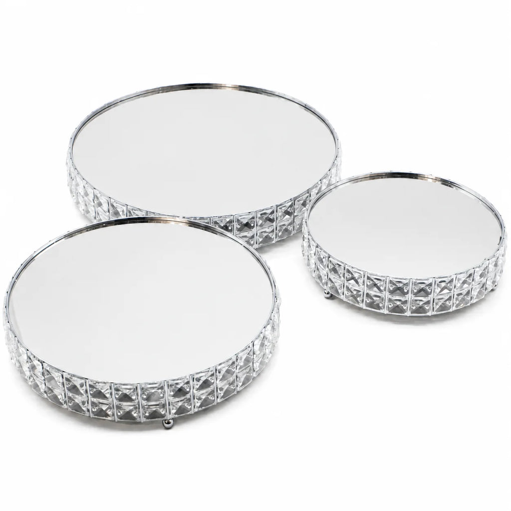 Three round mirrored coasters with decorative silver edge on a white background