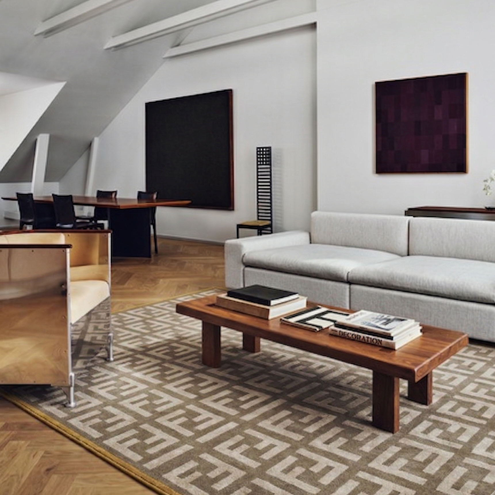 Modern living room with gray sofa, wooden coffee table, and patterned rug.