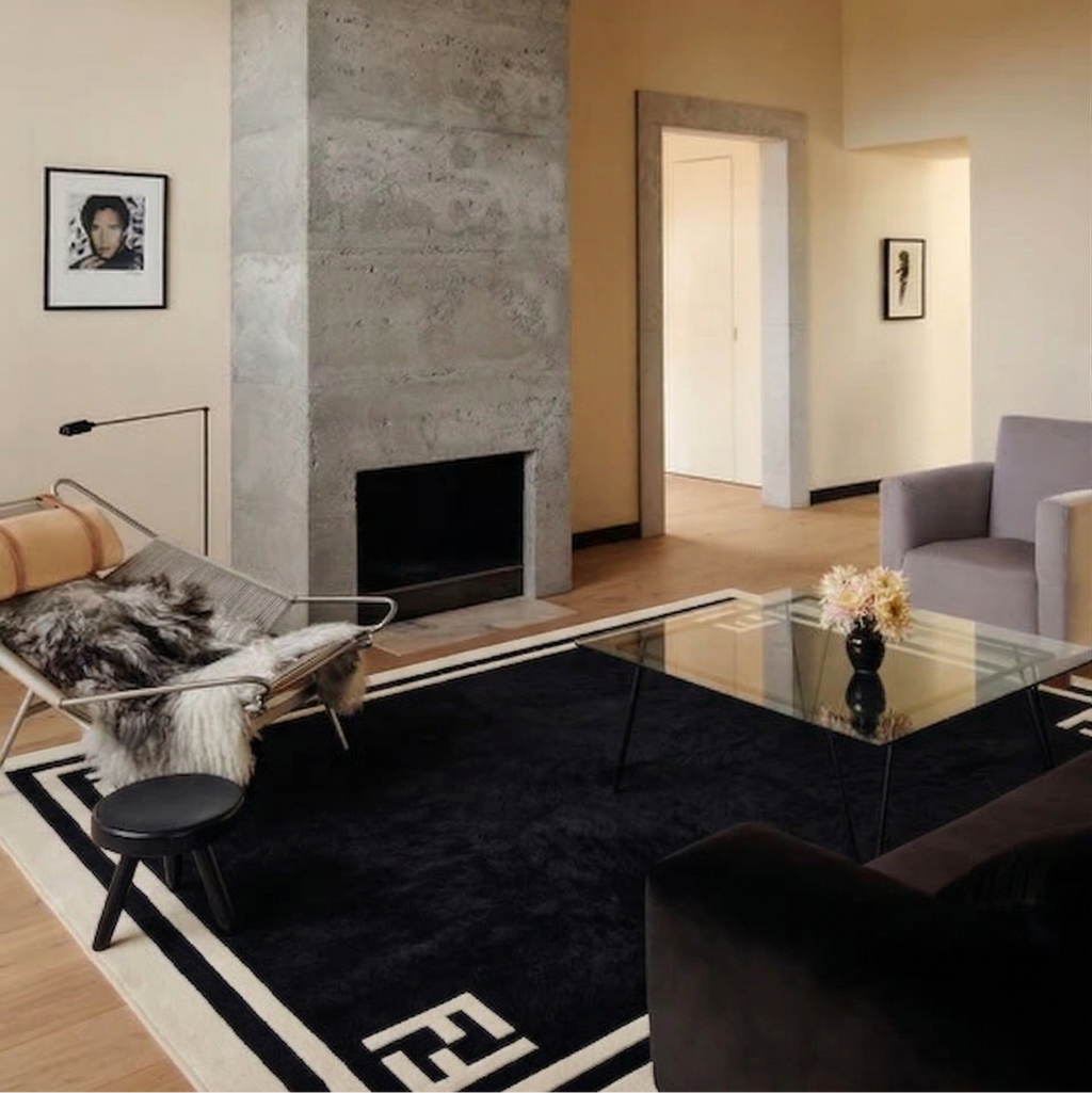 Modern living room with a fireplace, glass coffee table, and decorative items.