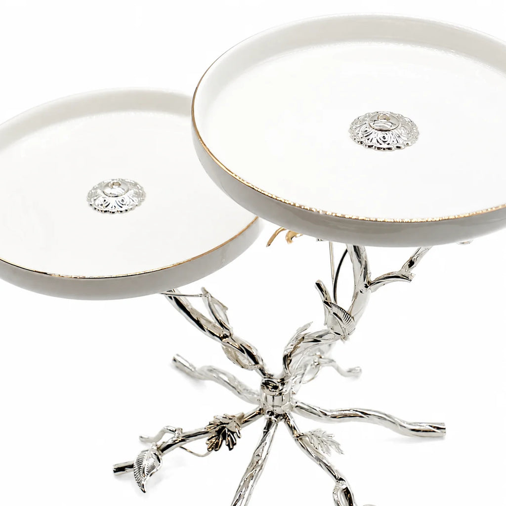 Decorative silver stand with branch-like design on a white background