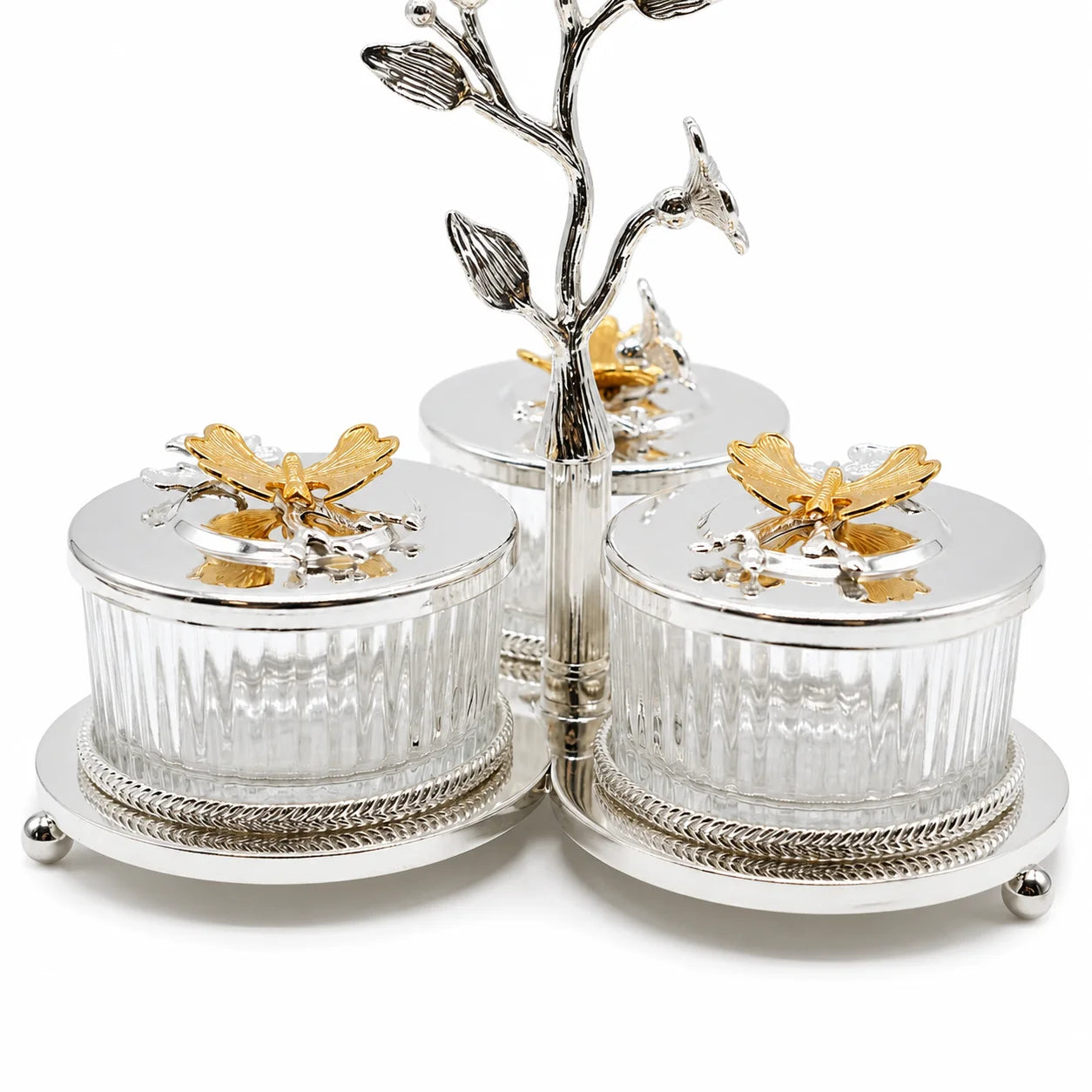 Three-piece silver and gold bird-themed caddy set, featuring three ribbed glass jars with silver lids topped with gold bird figurines, mounted on a silver branch stand with small bird perches.