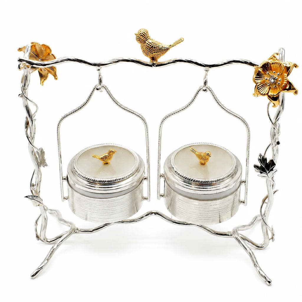 Decorative salt and pepper shaker set with silver stand and gold accents on a white background