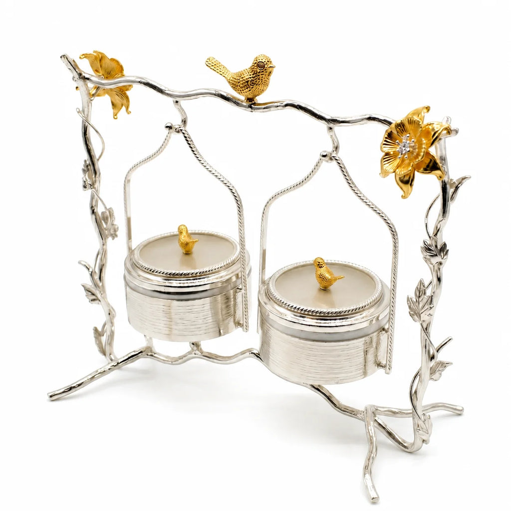 Decorative silver and gold jewelry stand with bird and flower details on a white background