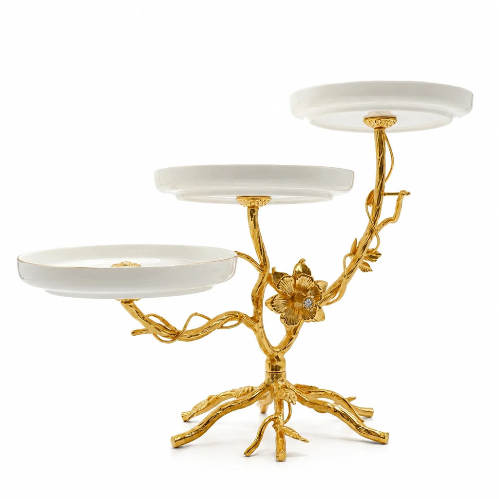 Three-tiered serving tray with gold branch-like design on a white background