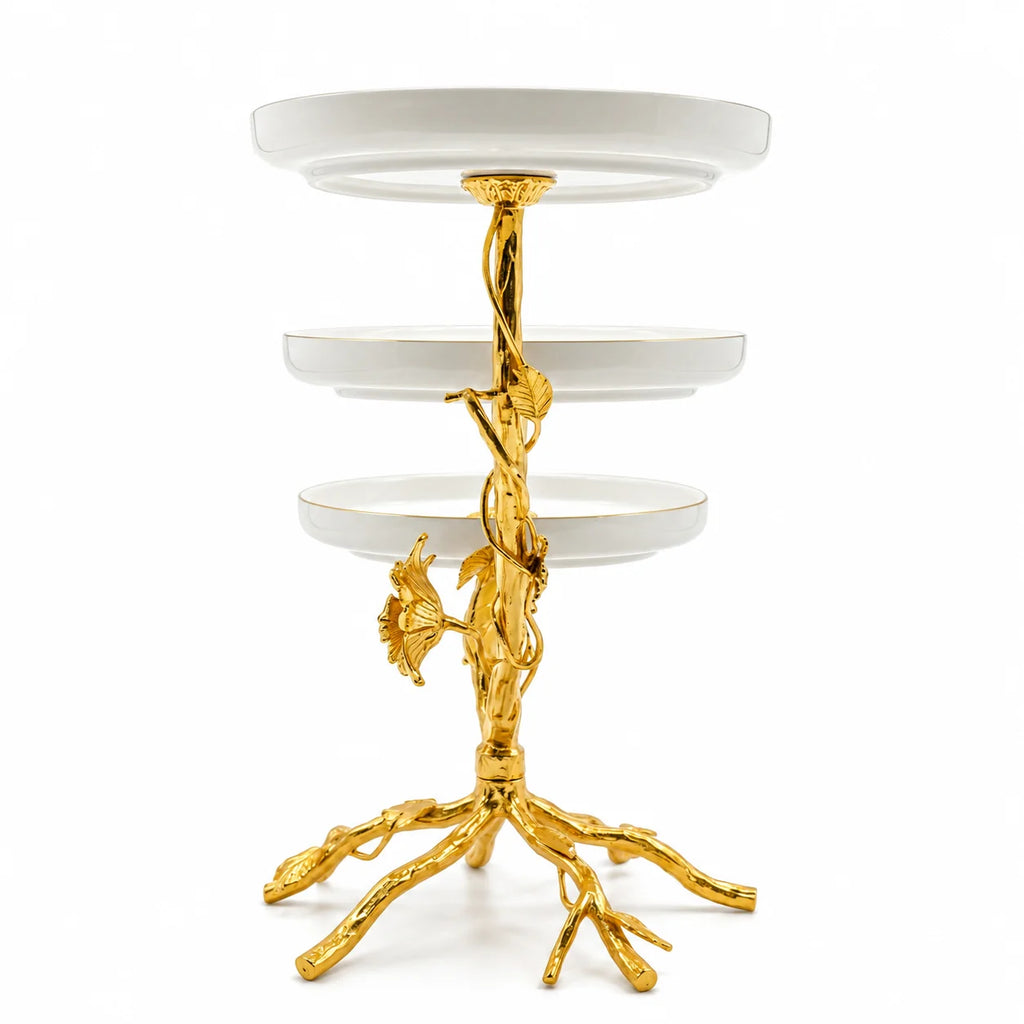 Decorative three-tiered stand with gold base and white shelves on a white background