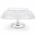 Clear glass cake stand with silver base on a white background