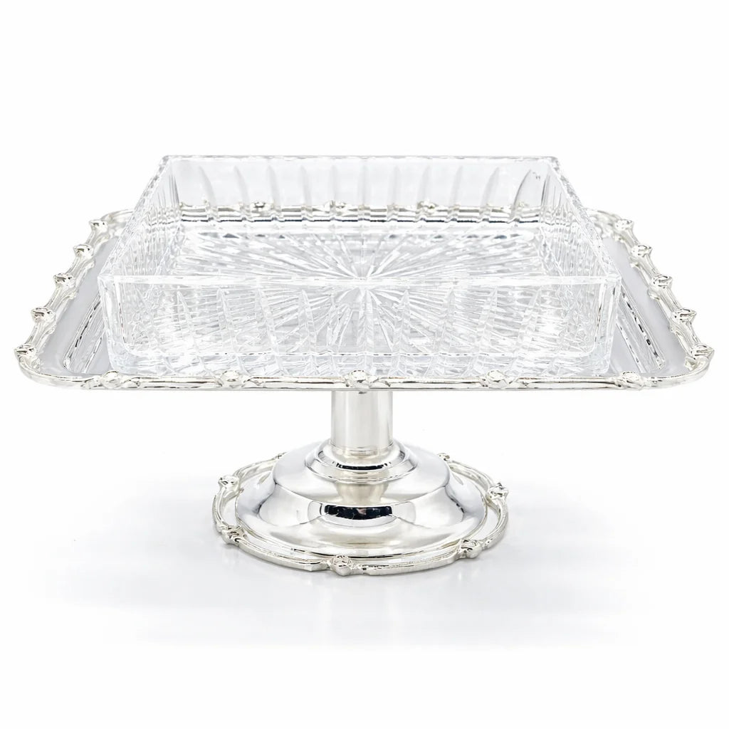 Clear glass cake stand with silver base on a white background