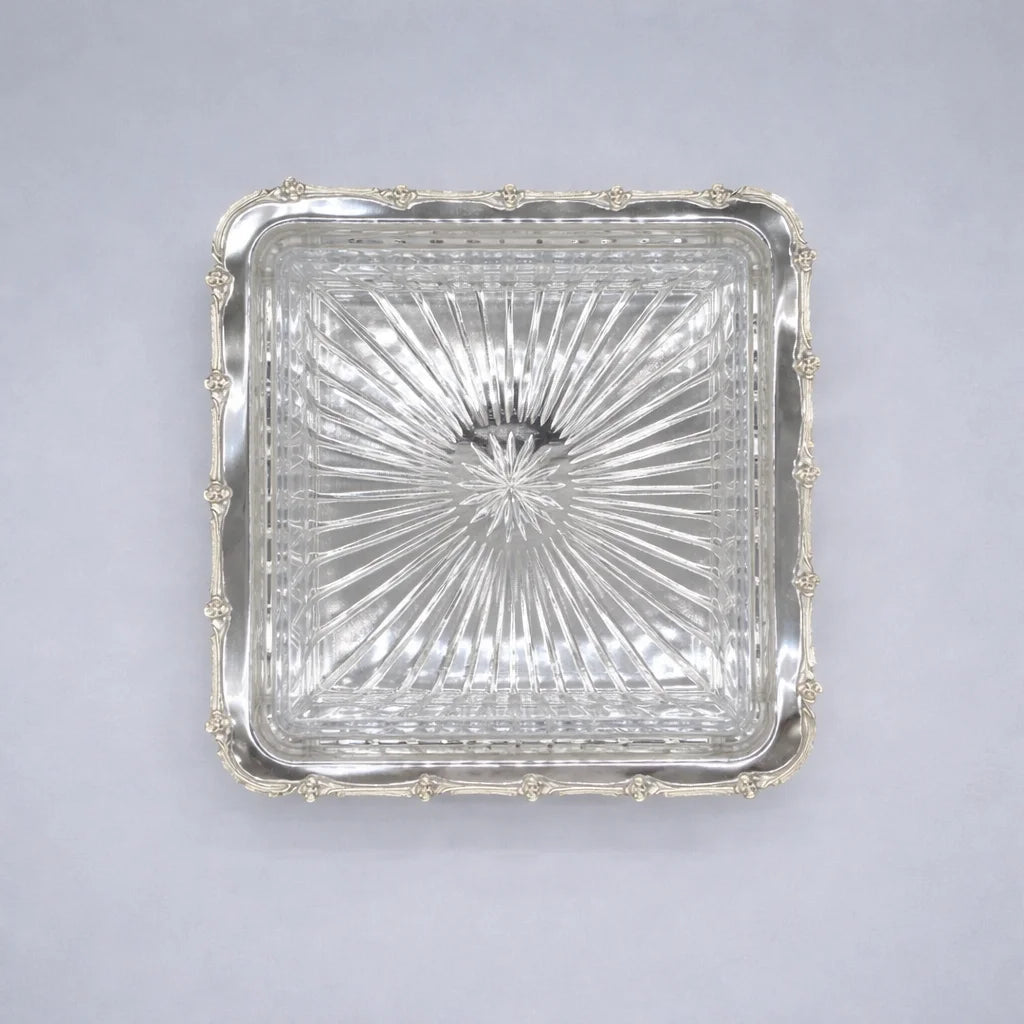 Square glass dish with silver rim on a gray background