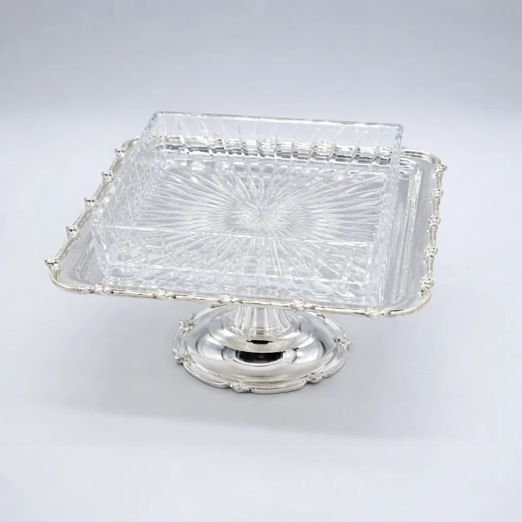 Clear glass dish with silver base on a white background