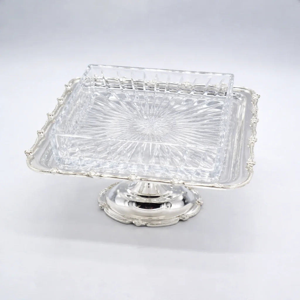 Clear glass dish with silver base on a white background