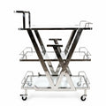 Metallic bar cart with glass shelves on a white background